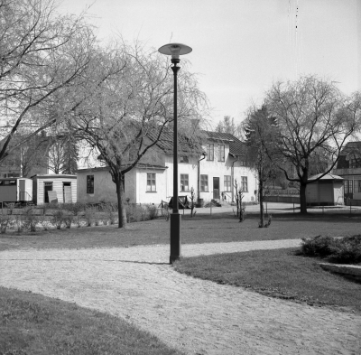 Källängsparken 

Bykällan till höger (P. Kastman 1747 se ock. Craelius 1774).  Vita huset s.k. Gamla epidemisjukhuset. var på 1930 tillfälligt ålderdomshem. Blev sedan möbelaffär och snickeri drevs av Gustav Larsson, övertogs sedan av Ivar Gustavsson. Huset revs år? T.E.


Dok.110408/KG

