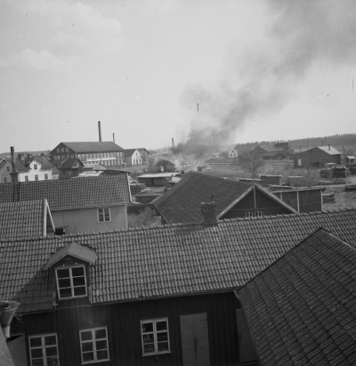 Eldsvåda vid Vimmerby Träförädling. Längst till höger syns det smalspåriga lokstallet som NVHJ använde på Spångenäsbanan och strax vänster om detta syns det stora lokstallet som ännu är kvar. Kortet är taget ifrån fastigheten Vallnäs som låg på Östra Tullportsgatan 4 nära Elon (2025)
- eldsvåda -

Dok.111021/KG