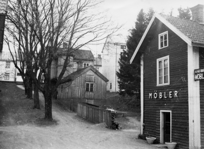 Barkliden 1950 sedd från från Sevedegatan.
I lilla huset bodde Alva och Frille Karlsson med barnen  Lasse, Nisse och Bosse.

Till höger: Håkanssons möbler.  Stora huset till höger om Nils Svensson, Storgatan 13, 6 lägenheter.  Där bodde Emil Andersson med barnen Arne och Tage senare Stackerud.  Arne blev frisör, gift med Britta som var syster med Olle Bäcklund.
Inga- May Andersson, gymnastikledare. Dagny Forsberg som arbetade på Rosin. Lars och Karin Rundqvist adopterade Stig Rundqvist.  Erin Hultgren gift med Sten Karlberg, Karlbergs skor.
Napoleon och Sofia Karlsson, skomakare hos Borgstrand.  Karlsson-stolpjocke, arbetade telefon därav namnet. Karlssons barn Harry, Villy, Dagmar och Sven. De tre pojkarna spelade cello, violin och piano på Nationalbiografen, Sevedegården.
Starbiografen på Sevedegatan slogs igen 1936. Ägare Wenström. Nu Sveasalen. Tidigaste filmen var "Fyrtornet och släpvagnen".
I  det mörka huset i bakrunden  bodde Holger Lindström. I det vita huset  bakom lönnen bodde byggmästare Robert Össt. Roberts barn Elsa och Margareta, telefonister, samt Åke och Gunnar. I huset längst till vänster ,plåtslagare Martin Dahlin med fru Elsa.
Uppgiftslämnare: Cirkel Eken/Elsy Nilsson. Nils Stenberg född på Storgatan 1917.

Huset till vänster i bakgrunden Storgatan 20 och nästa hus till höger Storgatan 11 var uppfört i början av 1900-talet av ägare Emil Andersson.  Det lilla huset mitt i backen är tidigare omnämnt på bild nr 7113.
Möbelaffären tillhörde Artur Håkansson, byggnaden revs sedan verksamheten flyttat till Storgatan år 1963.  Mellan det lilla huset och möbelaffären byggdes under andra världskriget ett splitterskydd mot bomber.
Backen var vintertid en populär vintersportplats bland yngre kringboende som nyttjade den med livet som insats på grund av att backen slutade tvärt vid Sevedegatan.  Alla husen hitom Storgatan revs på 60-talet för att ge plats åt HSB.
Uppgiftslämnare: Gösta Leander  021130

Dok.090128/SJ
