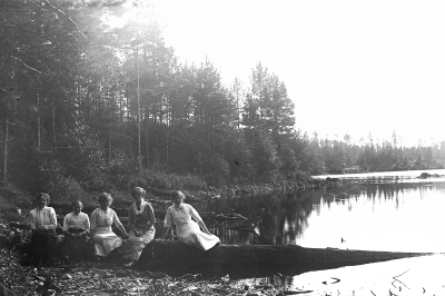 Fem damer vid en sjö.