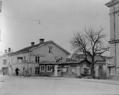 Bursieska huset före rivningen 1958 Baracken Bergs Cigarraffär och i Hotellet Rudells Skoaffär och Åbergs Barnkläder under byggnads tiden av Lundbergska huset 1957-58. T.E