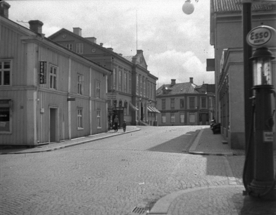 Sevedegatan mot Stora torget, okänt årtal. Intill Hotellträdgårdens entré syns en pissoar som kallades “Gröna nöden” i folkmun. (Bildid. 18749)