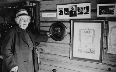 Fru Agnes Wenström i Kopparslagarverkstaden i Gästgivarhagen, håller i ett porträtt av maken Oscar Wenström, gjort av sonen Josef Wenström i Silverdalen.   